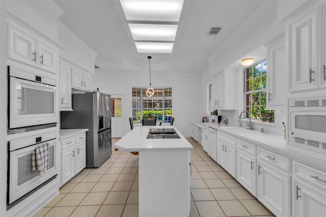 24 Stonegate Park Ct, Spring, TX 77379 - kitchen featuring appliances with stainless steel finishes, a sink, a kitchen island, and white cabinetry