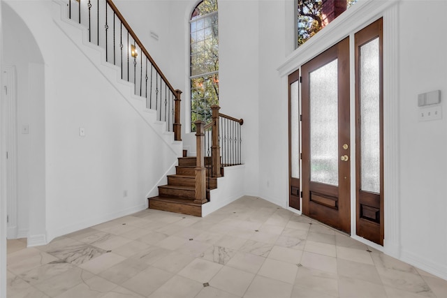 24 Stonegate Park Ct, Spring, TX 77379 - foyer entrance featuring plenty of natural light, stairway, arched walkways, baseboards, and a towering ceiling