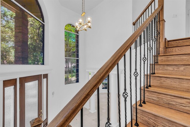 24 Stonegate Park Ct, Spring, TX 77379 - staircase with a towering ceiling, a chandelier, and arched walkways