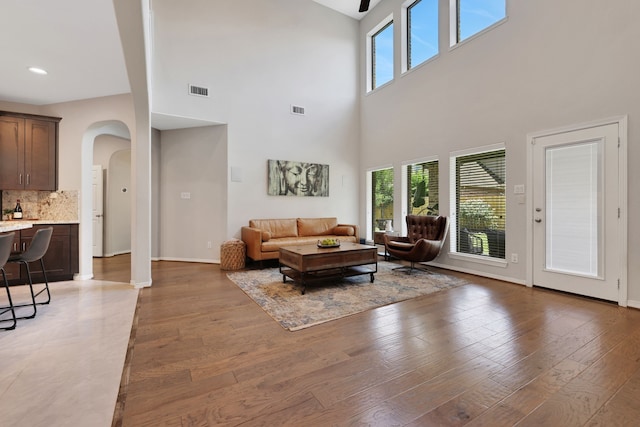 6706 Miller Shadow Ln, Sugar Land, TX 77479 - living area featuring arched walkways, a high ceiling, light wood-style flooring, baseboards, and recessed lighting
