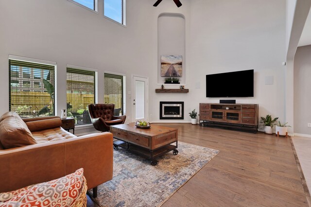 6706 Miller Shadow Ln, Sugar Land, TX 77479 - living area featuring a high ceiling, wood finished floors, a fireplace, baseboards, and a ceiling fan