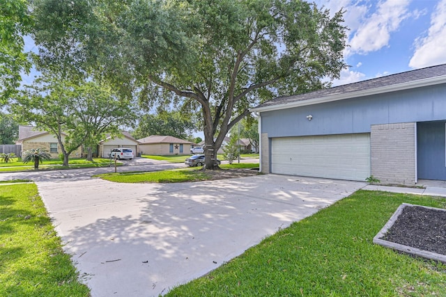 3915 Rosemont Dr, La Porte, TX 77571 - view of side of property with concrete driveway, brick siding, a residential view, a garage, and a yard
