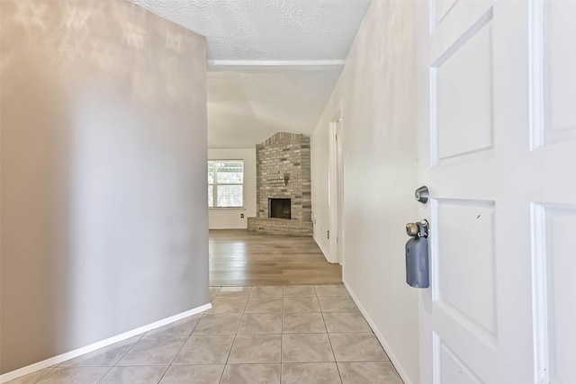 3915 Rosemont Dr, La Porte, TX 77571 - corridor with a textured ceiling, lofted ceiling, light tile patterned floors, and baseboards
