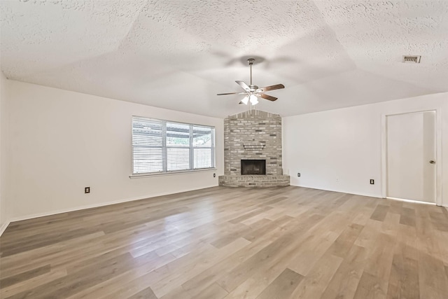 3915 Rosemont Dr, La Porte, TX 77571 - unfurnished living room with ceiling fan, a textured ceiling, light wood-type flooring, vaulted ceiling, and a fireplace