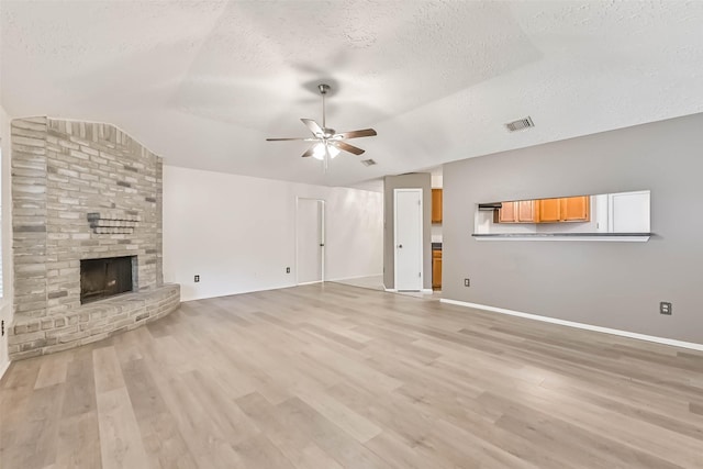 3915 Rosemont Dr, La Porte, TX 77571 - unfurnished living room with lofted ceiling, a textured ceiling, a ceiling fan, a fireplace, and light wood-type flooring