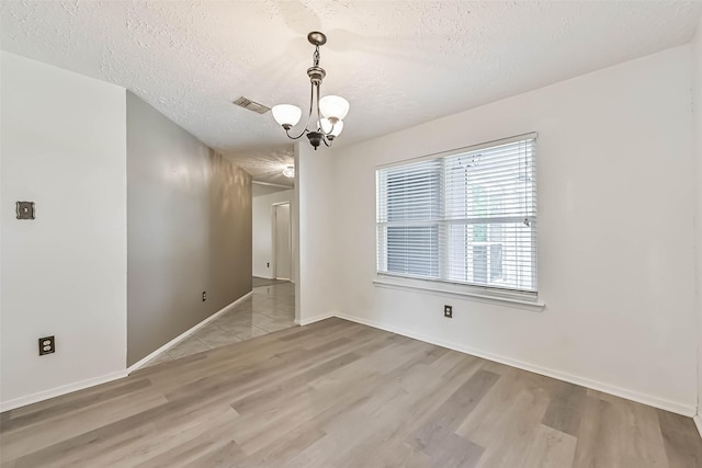 3915 Rosemont Dr, La Porte, TX 77571 - empty room featuring wood finished floors, a textured ceiling, a chandelier, and baseboards