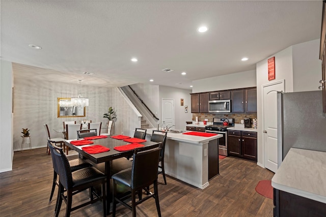 21512 Rustic Elm Dr, New Caney, TX 77357 - kitchen with stainless steel appliances, dark brown cabinetry, light countertops, dark wood-style flooring, and recessed lighting