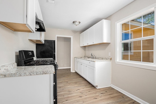 7306 Lakewood Dr, Houston, TX 77016 - kitchen with a sink, black appliances, baseboards, and light wood-type flooring