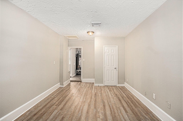7306 Lakewood Dr, Houston, TX 77016 - unfurnished room with baseboards, wood finished floors, attic access, and a textured ceiling