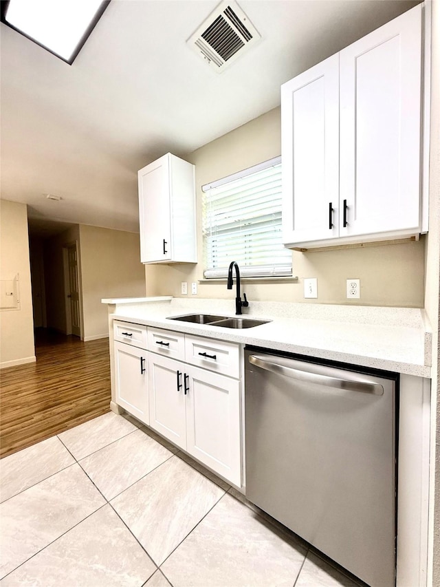 7600 Emmett F Lowry Expy Unit 409, Texas City, TX 77591 - kitchen with stainless steel dishwasher, a sink, light countertops, white cabinetry, and light tile patterned floors