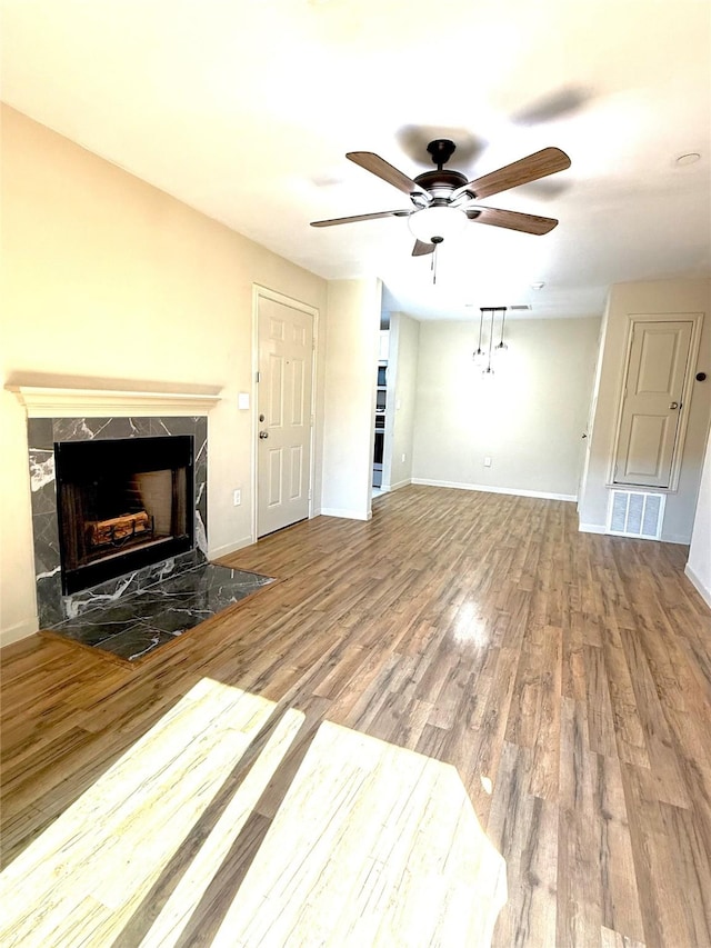 7600 Emmett F Lowry Expy Unit 409, Texas City, TX 77591 - unfurnished living room with ceiling fan, a premium fireplace, wood finished floors, and baseboards