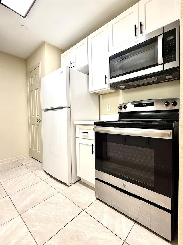 7600 Emmett F Lowry Expy Unit 409, Texas City, TX 77591 - kitchen with stainless steel appliances, white cabinetry, light tile patterned floors, and baseboards