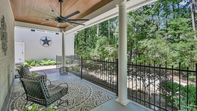 view of patio featuring a ceiling fan and view of scattered trees