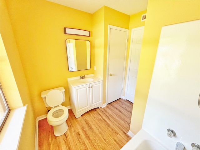 803 Wolley Cir, Crockett, TX 75835 - bathroom with wood finished floors, toilet, vanity, and baseboards