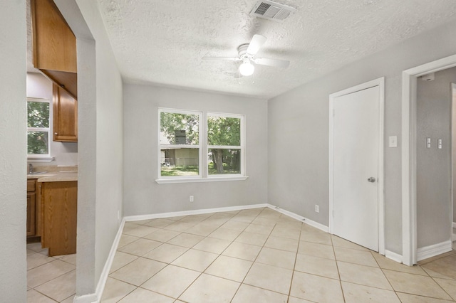 2705 Camille St, Pasadena, TX 77506 - unfurnished room featuring plenty of natural light, a textured ceiling, a ceiling fan, light tile patterned floors, and baseboards