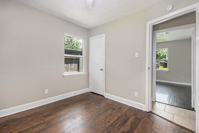 2705 Camille St, Pasadena, TX 77506 - unfurnished room featuring a smoke detector, baseboards, wood-type flooring, plenty of natural light, and a textured ceiling