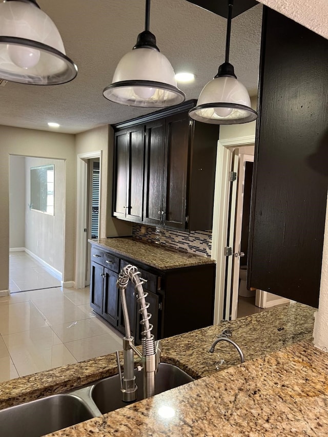 1506 Grand Valley Dr, Houston, TX 77090 - kitchen with a sink, stone countertops, light tile patterned floors, baseboards, and decorative light fixtures