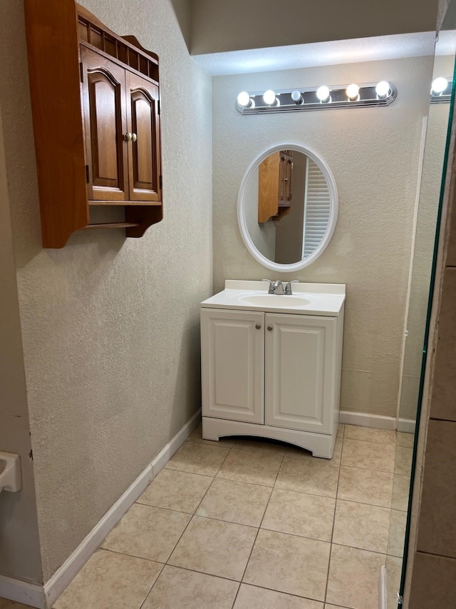 1506 Grand Valley Dr, Houston, TX 77090 - bathroom with tile patterned flooring, vanity, a textured wall, and baseboards