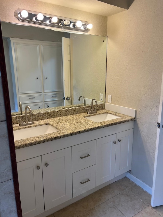 1506 Grand Valley Dr, Houston, TX 77090 - full bathroom featuring tile patterned floors, a textured wall, double vanity, and baseboards