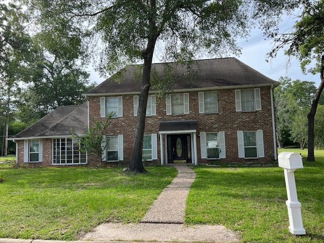 1506 Grand Valley Dr, Houston, TX 77090 - view of front facade with a front yard, brick siding, and a shingled roof