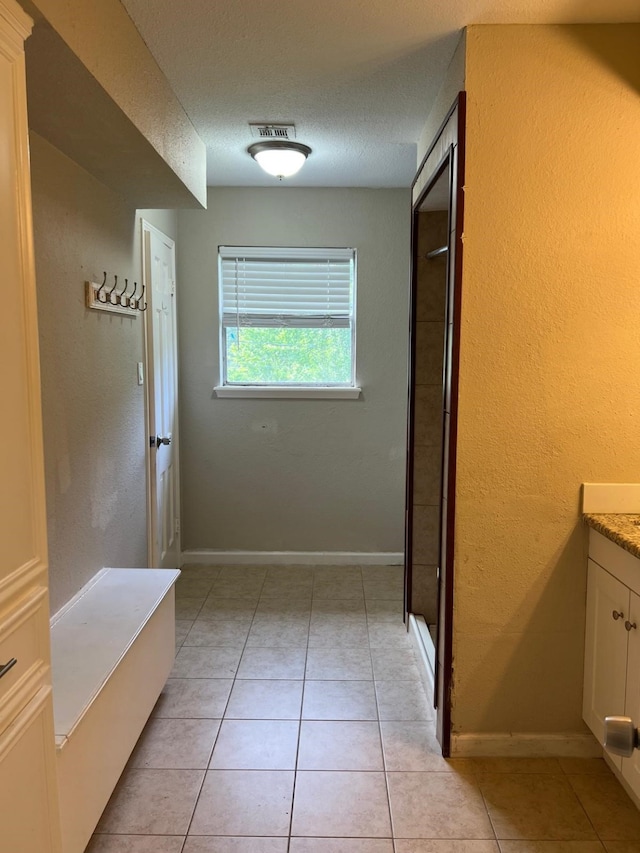 1506 Grand Valley Dr, Houston, TX 77090 - bathroom featuring vanity, a textured wall, baseboards, tile patterned flooring, and a shower