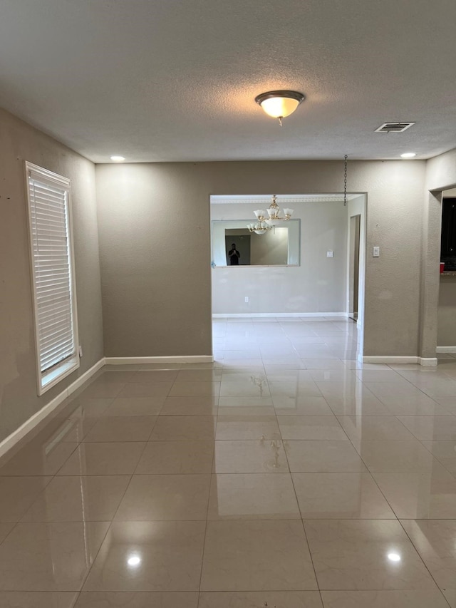 1506 Grand Valley Dr, Houston, TX 77090 - tiled empty room featuring a chandelier, baseboards, and a textured ceiling