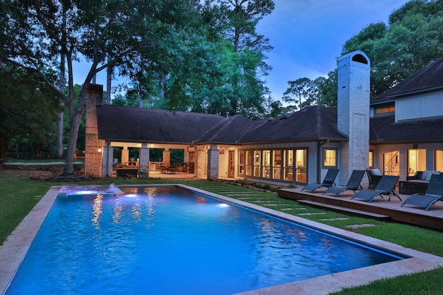 23025 Jane Rd, Tomball, TX 77377 - pool at dusk featuring an outdoor pool, a deck, and a patio
