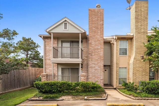 3100 Jeanetta St Unit 606, Houston, TX 77063 - view of front facade featuring a balcony, a chimney, fence, and brick siding