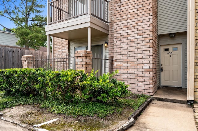 3100 Jeanetta St Unit 606, Houston, TX 77063 - doorway to property featuring a balcony, brick siding, and fence