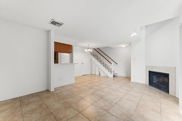 3100 Jeanetta St Unit 606, Houston, TX 77063 - unfurnished living room with a chandelier, a high end fireplace, stairway, light tile patterned floors, and a textured ceiling