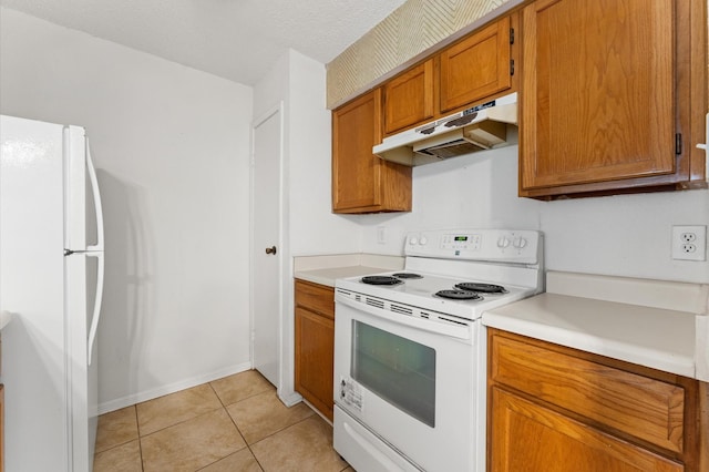 3100 Jeanetta St Unit 606, Houston, TX 77063 - kitchen with white appliances, under cabinet range hood, brown cabinets, light countertops, and light tile patterned flooring