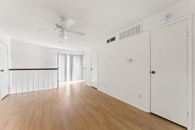3100 Jeanetta St Unit 606, Houston, TX 77063 - empty room featuring ceiling fan, light wood-style flooring, a textured ceiling, a smoke detector, and baseboards