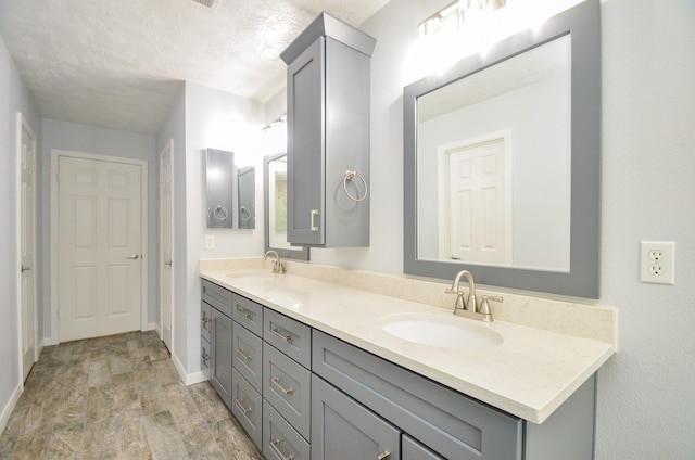 13523 Spring Ct, Tomball, TX 77375 - full bathroom featuring baseboards, a textured ceiling, and double vanity
