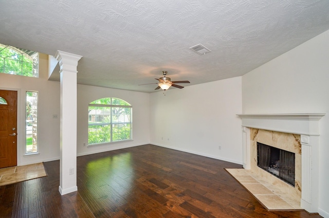 13523 Spring Ct, Tomball, TX 77375 - unfurnished living room featuring ceiling fan, hardwood / wood-style flooring, a textured ceiling, a fireplace, and decorative columns
