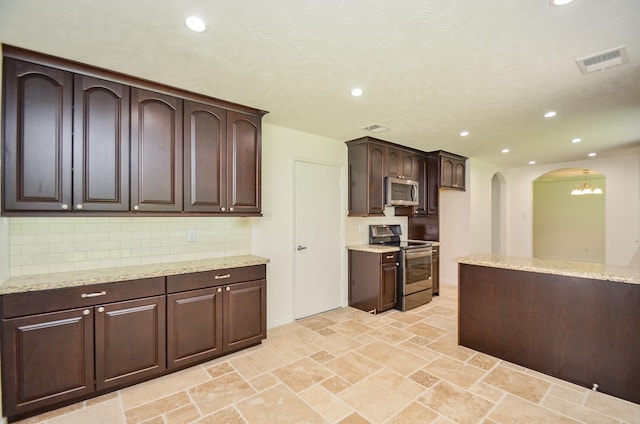 13523 Spring Ct, Tomball, TX 77375 - kitchen featuring appliances with stainless steel finishes, arched walkways, recessed lighting, backsplash, and dark brown cabinetry