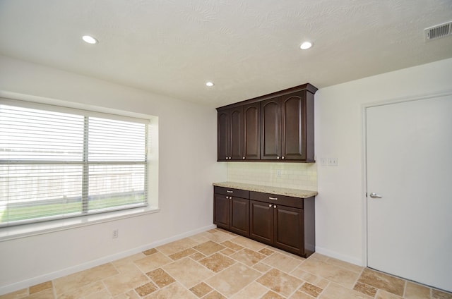 13523 Spring Ct, Tomball, TX 77375 - kitchen featuring baseboards, dark brown cabinetry, stone tile floors, and recessed lighting