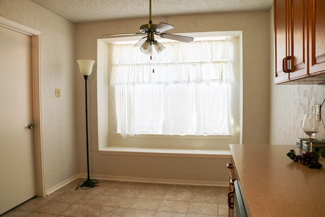 9922 Hibernia Dr, Houston, TX 77088 - unfurnished dining area with ceiling fan, plenty of natural light, a textured ceiling, and baseboards