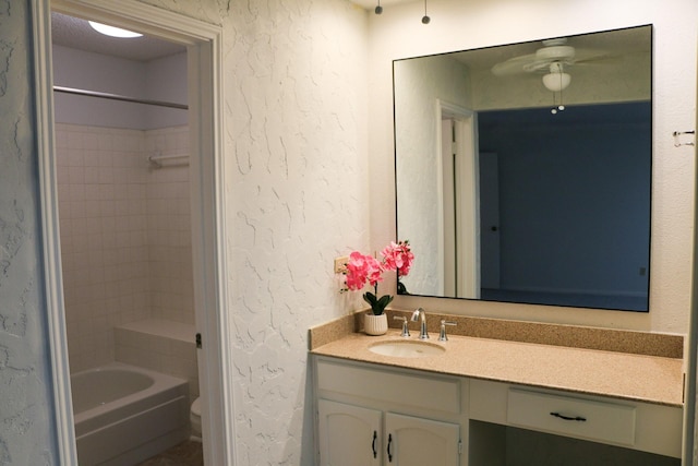 9922 Hibernia Dr, Houston, TX 77088 - bathroom featuring vanity, a textured wall, ceiling fan, tub / shower combination, and toilet