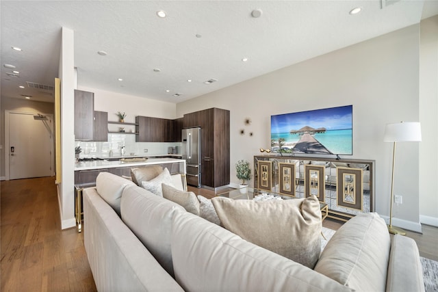 1211 Caroline St Unit 908, Houston, TX 77002 - living room with wood finished floors, recessed lighting, and baseboards