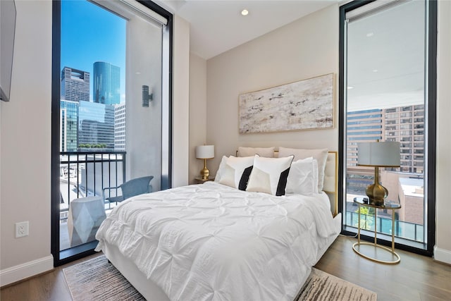 1211 Caroline St Unit 908, Houston, TX 77002 - bedroom featuring multiple windows, wood finished floors, baseboards, a city view, and recessed lighting