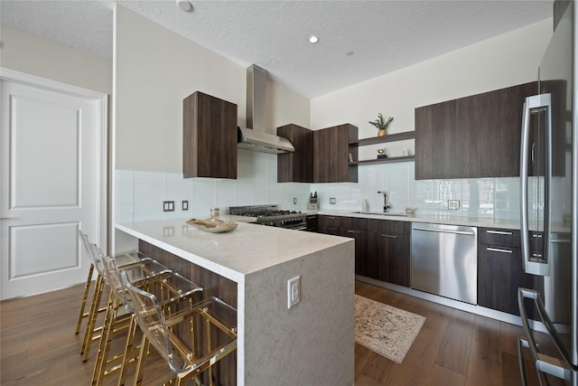 1211 Caroline St Unit 908, Houston, TX 77002 - kitchen featuring appliances with stainless steel finishes, wall chimney range hood, open shelves, modern cabinets, and a textured ceiling