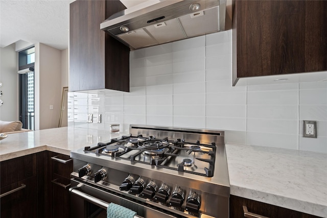 1211 Caroline St Unit 908, Houston, TX 77002 - kitchen featuring range hood, high end stainless steel range oven, dark brown cabinets, backsplash, and light stone countertops