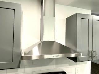 803 Hackberry St, Stafford, TX 77477 - kitchen view of wall chimney exhaust hood and gray cabinets