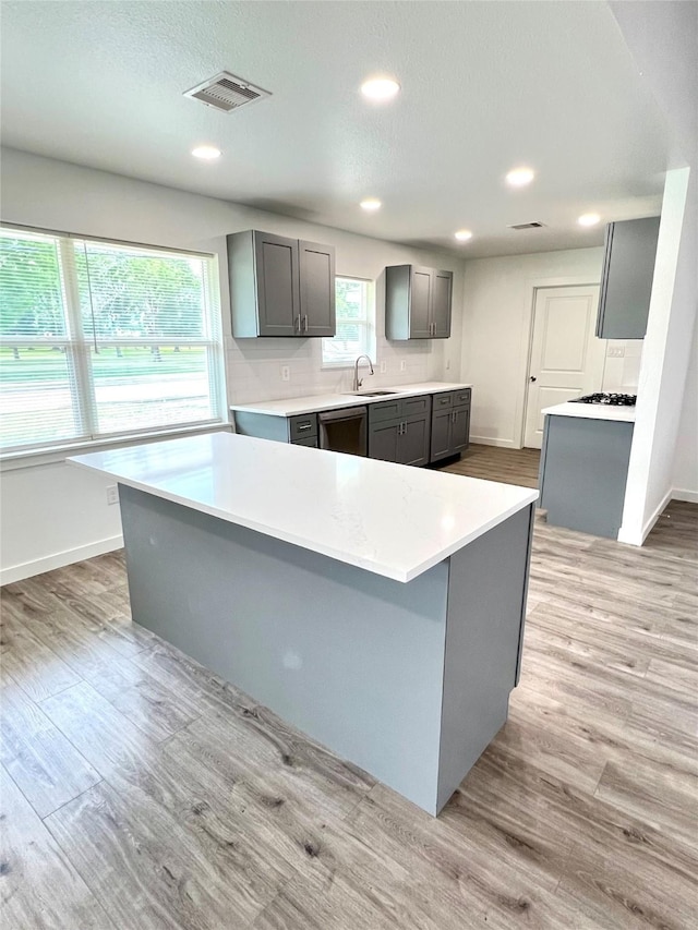 803 Hackberry St, Stafford, TX 77477 - kitchen featuring a sink, dishwasher, gray cabinets, light wood-type flooring, and baseboards