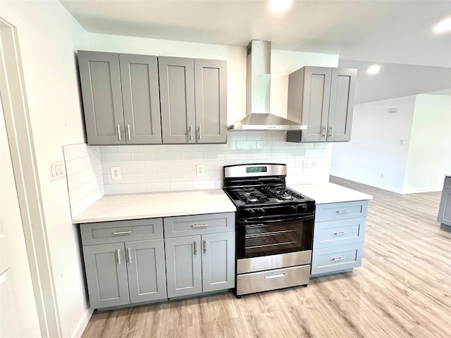 803 Hackberry St, Stafford, TX 77477 - kitchen with wall chimney range hood, stainless steel range with gas cooktop, gray cabinets, light wood-style flooring, and recessed lighting