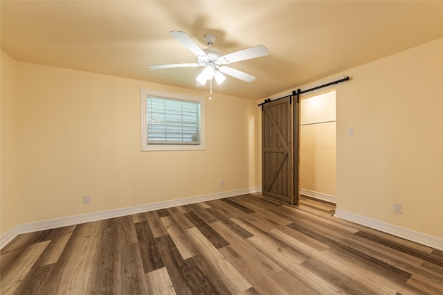 1535 Scott St, La Marque, TX 77568 - unfurnished bedroom with a barn door, wood finished floors, baseboards, and a ceiling fan