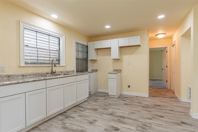 1535 Scott St, La Marque, TX 77568 - kitchen with a sink, light wood-style floors, white cabinets, recessed lighting, and baseboards