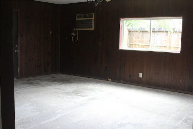 814 Kilpatrick St, Channelview, TX 77530 - spare room with wood walls, a wall unit AC, and unfinished concrete flooring