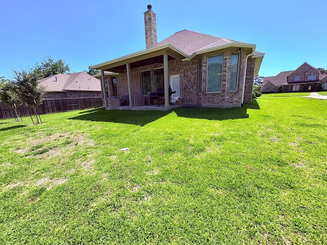 55 Ruskin Dr W, Montgomery, TX 77356 - rear view of property featuring a chimney, brick siding, and a patio