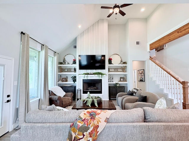 55 Ruskin Dr W, Montgomery, TX 77356 - living area featuring high vaulted ceiling, ceiling fan, stairs, wood finished floors, and a fireplace